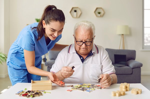 assisted-living-elderly-man-caregiver-puzzle-therapy